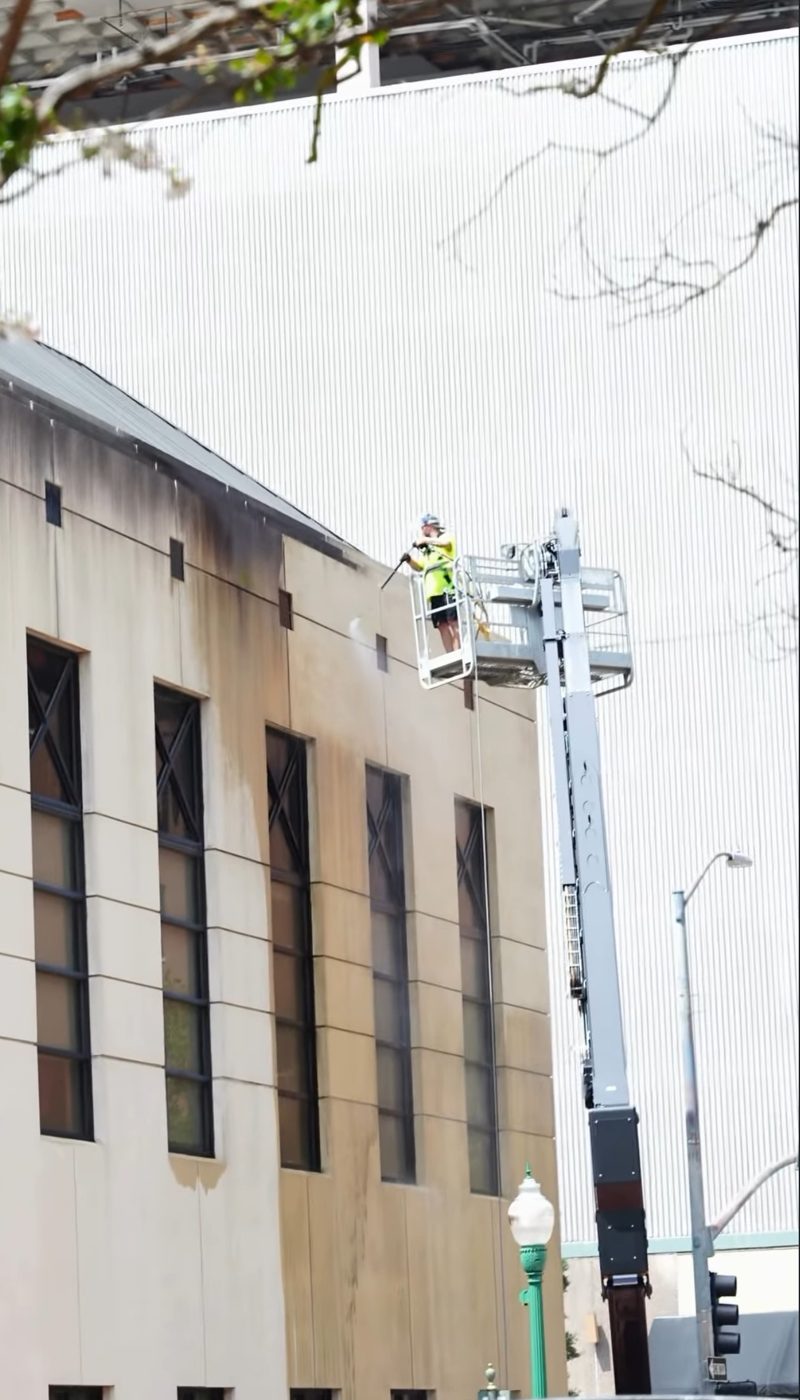 Lift crew washing a downtown facade